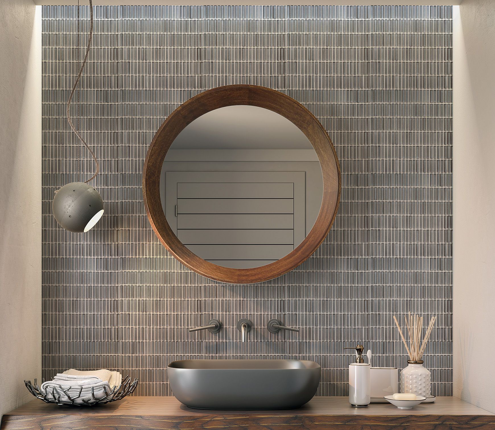 A dark grey sink on a wooden table, featuring a matching sink fixture, wooden round mirror and Gray Porcelain mosaic tiles on the wall.